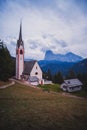 Church of St. JacobÃ¢â¬â¢s, Church of San GiacomoÃ¢â¬â¢s next to the town of Ortisei in the background with the mountains of the Royalty Free Stock Photo